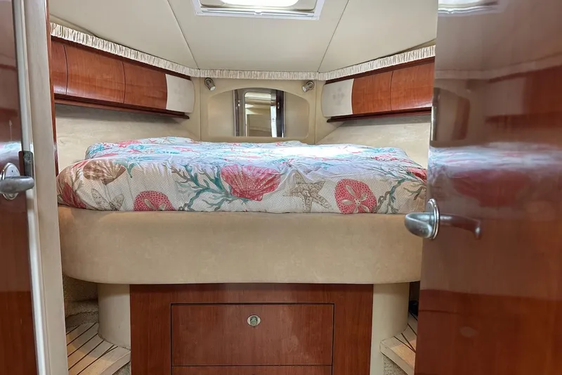 Slide: The Image of Luxurious 2004 Sea Ray 420 Sundancer cabin interior with cozy bed and elegant wood finish. - 17
