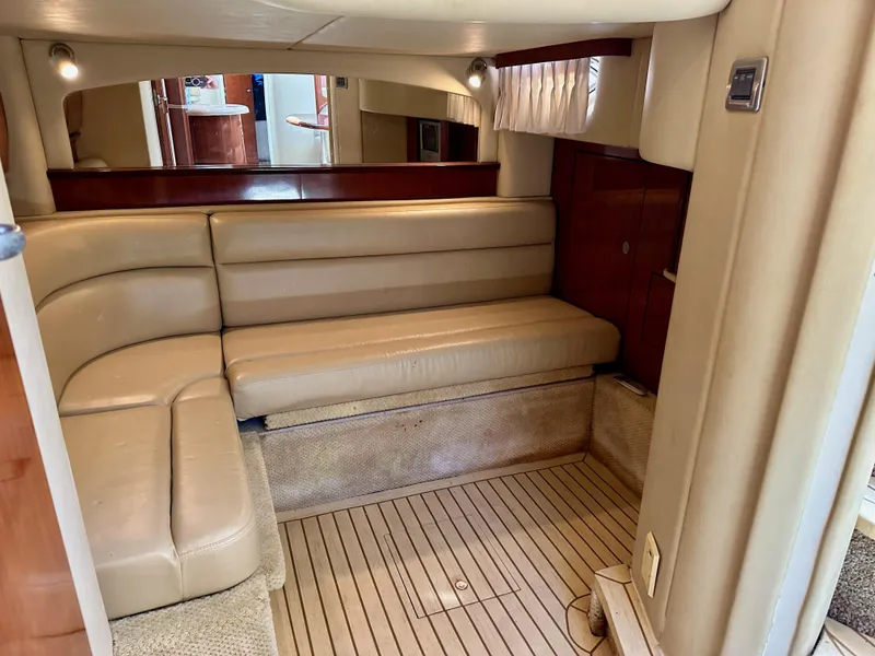 Slide: The Image of 2004 Sea Ray 420 Sundancer interior with beige leather seating and wooden flooring. - 22