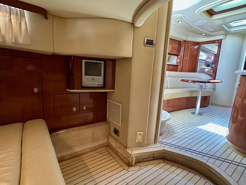 Slide: The Image of Interior of 2004 Sea Ray 420 Sundancer yacht, featuring elegant wood finishes and cozy seating. - 23