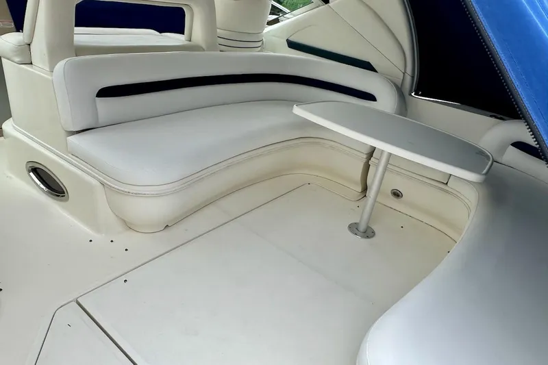 Slide: The Image of Interior seating area of 2004 Sea Ray 420 Sundancer with white upholstery and table. - 33