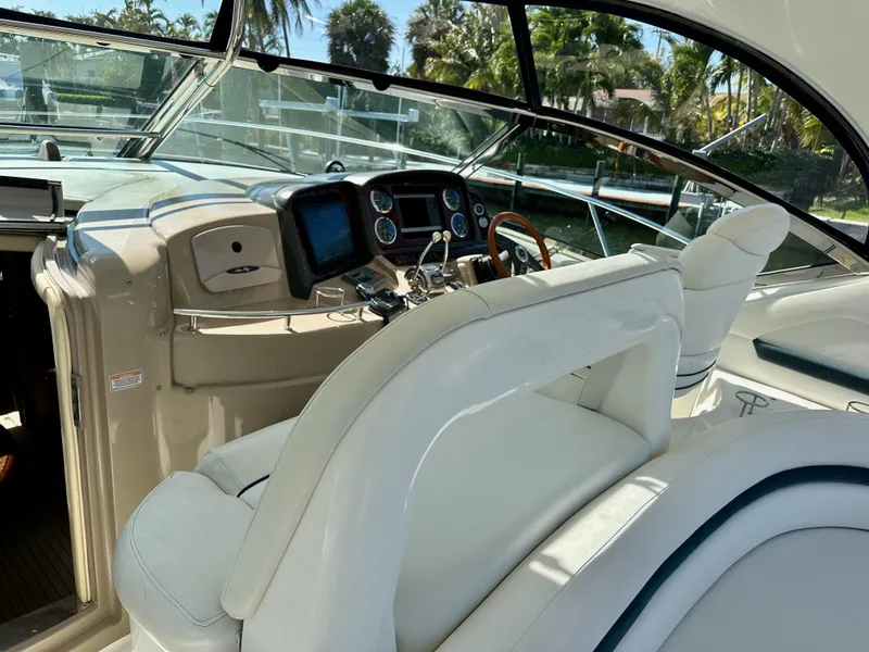 Slide: The Image of 2004 Sea Ray 420 Sundancer helm with white seating and modern controls. - 7