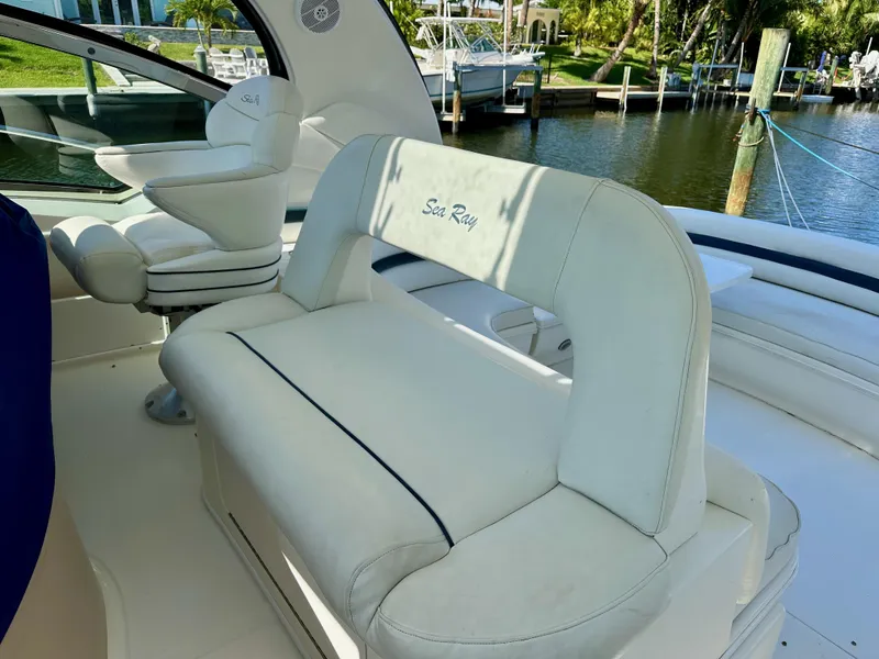 Slide: The Image of 2004 Sea Ray 420 Sundancer boat interior with white seating and waterfront view. - 8