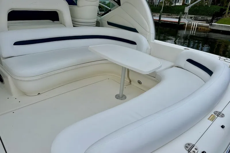 Slide: The Image of 2004 Sea Ray 420 Sundancer boat interior with white seating and table by the water. - 9