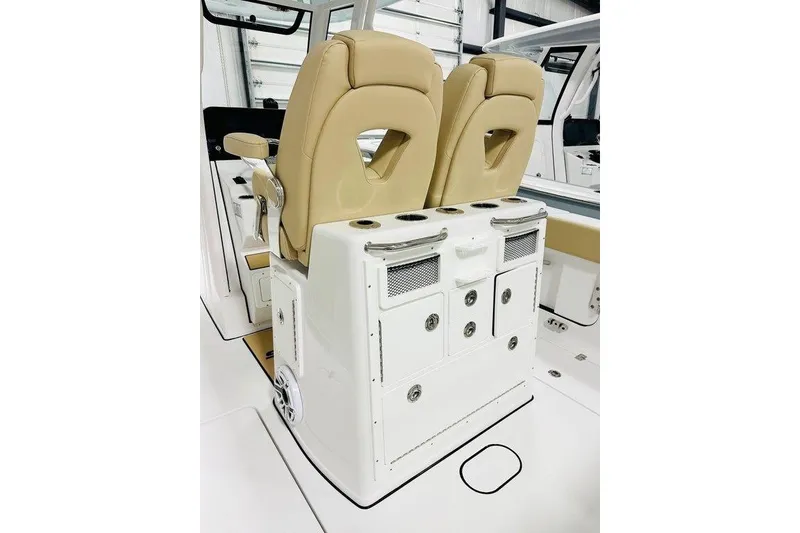 Slide: The Image of 2026 Sportsman Open 262 Center Console boat interior with tan seats and storage compartments. - 8