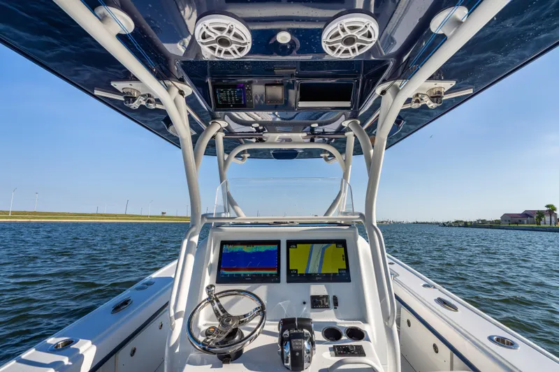 Slide: The Image of 2021 Yellowfin 32 Offshore boat dashboard with navigation screens on open water. - 12