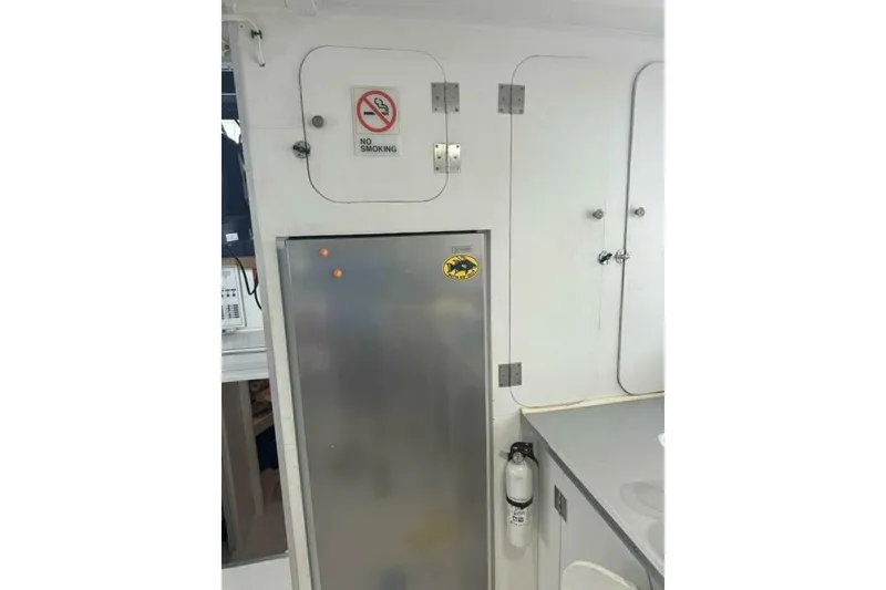 Slide: The Image of 1987 Monroe Custom 52 interior with no smoking sign and stainless steel cabinet. - 16