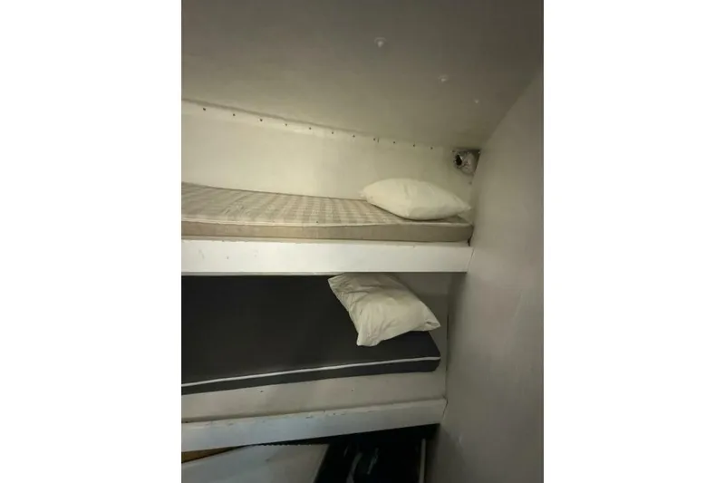 Slide: The Image of Bunk beds inside a 1987 Monroe Custom 52, featuring simple mattresses and pillows. - 26