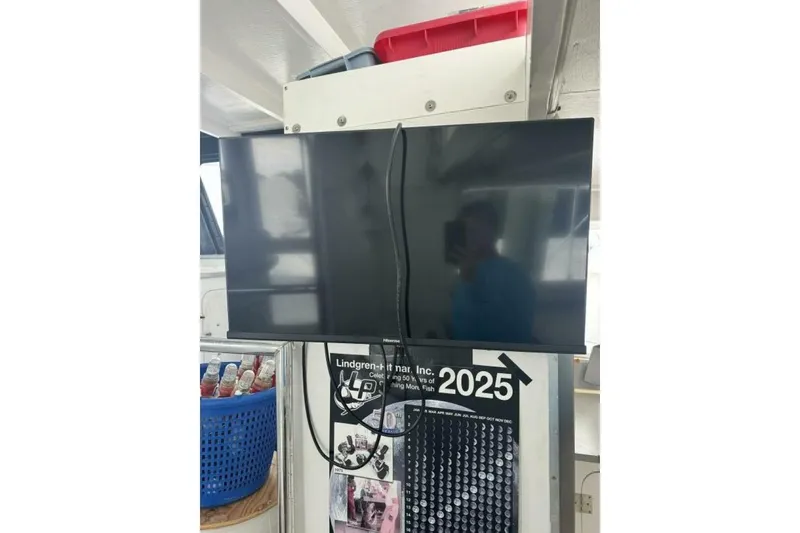 Slide: The Image of Flat-screen TV mounted above a calendar, with a blue basket nearby. - 32