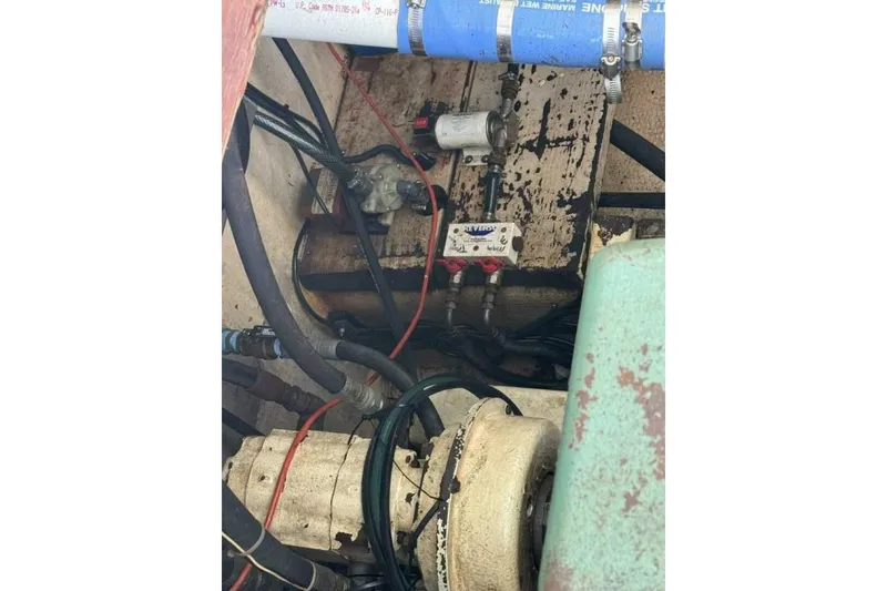 Slide: The Image of Engine compartment of a 1987 Monroe Custom 52, showing hoses and mechanical components. - 38