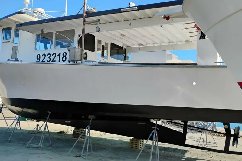 Slide: The Image of 1987 Monroe Custom 52 boat on stands, hull number 923218, in a shipyard. - 4