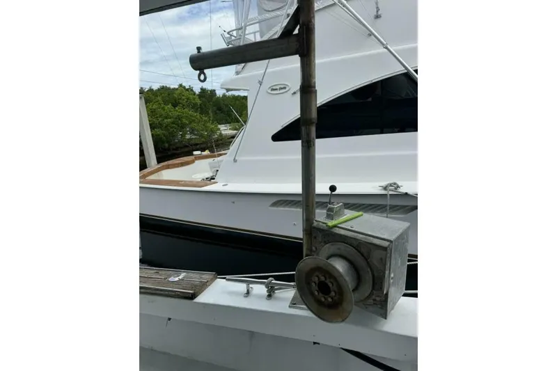 Slide: The Image of Fishing equipment on a 1987 Monroe Custom 52 boat, docked near greenery. - 43