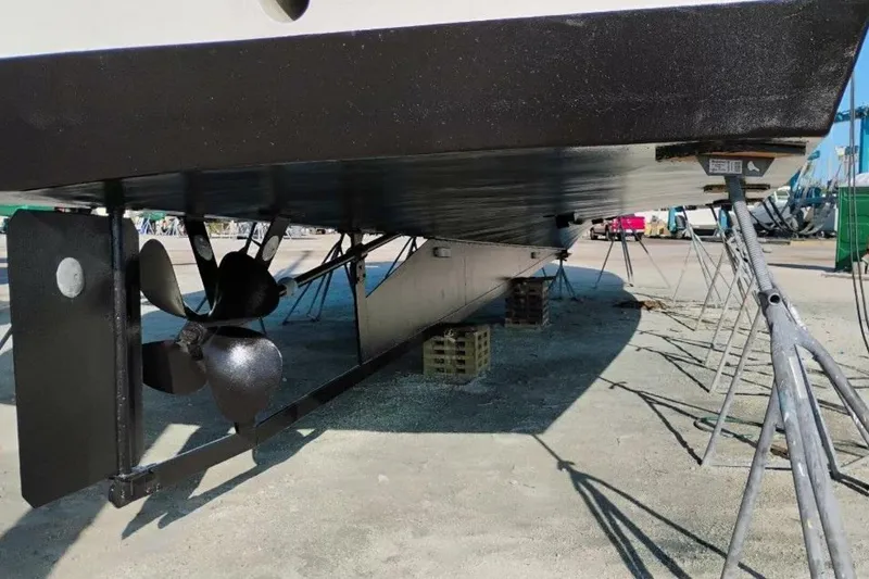 Slide: The Image of Underneath view of a 1987 Monroe Custom 52 boat on stands, showing propeller and rudder. - 7