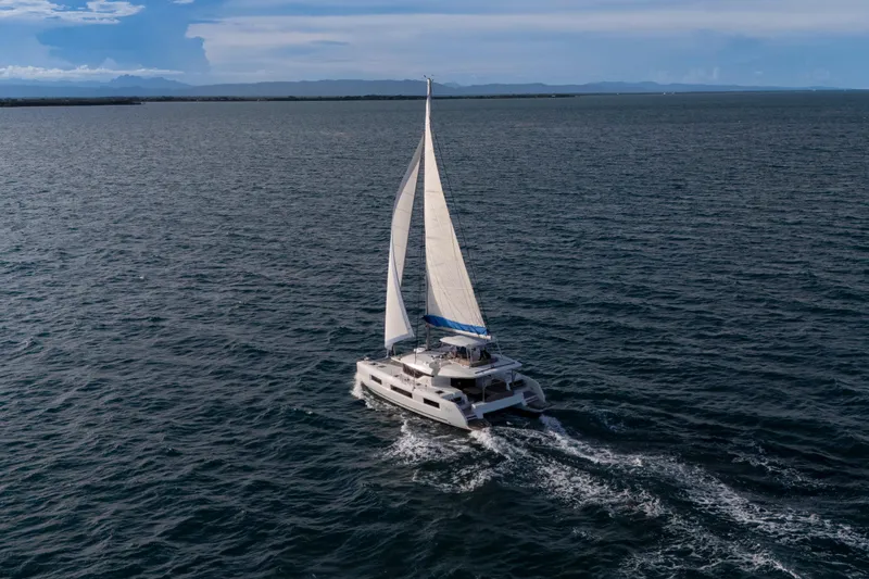 Slide: The Image of 2024 Lagoon 51 catamaran sailing on open sea under clear skies. - 11