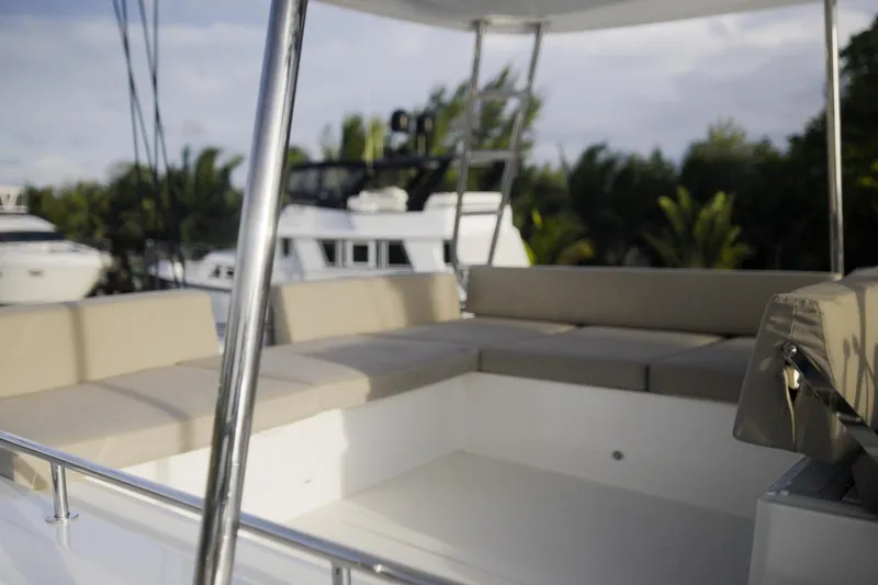 Slide: The Image of Luxurious seating area on 2024 Lagoon 51 yacht, surrounded by lush greenery. - 12