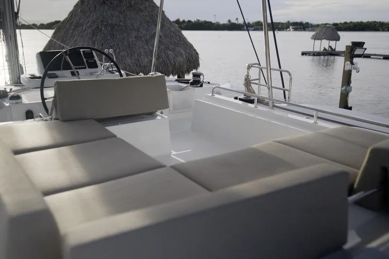 Slide: The Image of 2024 Lagoon 51 yacht interior with cushioned seating, overlooking serene waters. - 13