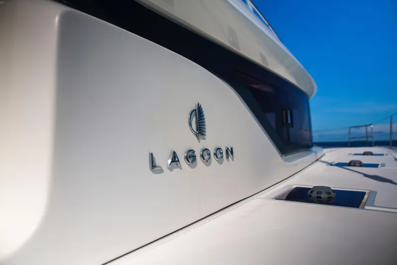 Slide: The Image of 2024 Lagoon 51 yacht, sleek design with logo, against a clear blue sky. - 18
