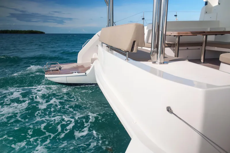 Slide: The Image of 2024 Lagoon 51 catamaran on turquoise sea, featuring spacious deck and seating area. - 21