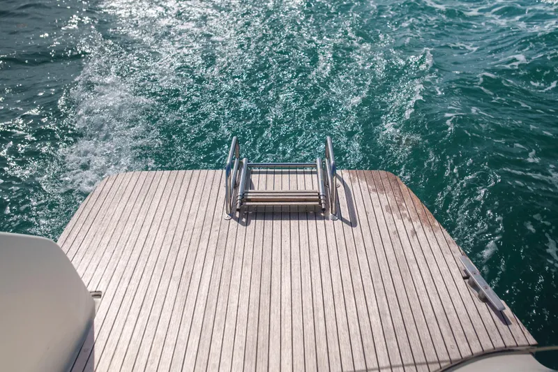 Slide: The Image of Stern view of 2024 Lagoon 51 yacht with swim platform and ocean waves. - 22