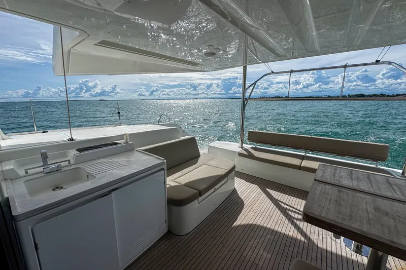 Slide: The Image of Luxurious 2024 Lagoon 51 yacht interior with ocean view, featuring seating and kitchenette. - 23