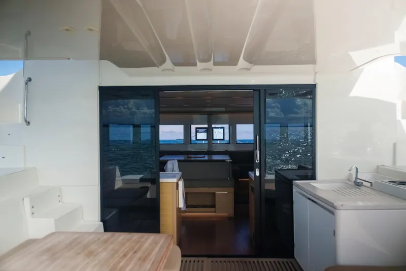 Slide: The Image of 2024 Lagoon 51 yacht interior with ocean view through glass doors. - 25