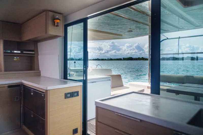 Slide: The Image of Interior view of 2024 Lagoon 51 yacht with ocean backdrop through sliding doors. - 29