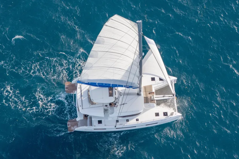 Slide: The Image of Aerial view of 2024 Lagoon 51 catamaran sailing on blue ocean waters. - 3