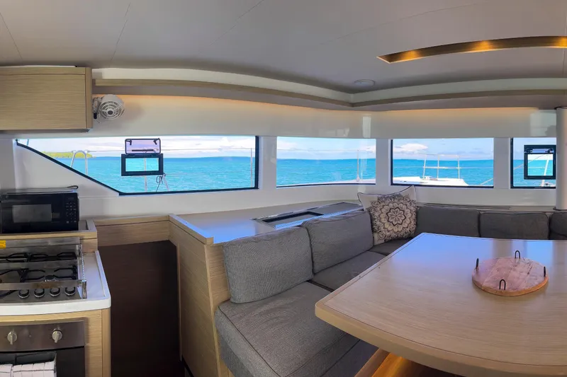 Slide: The Image of Interior of 2024 Lagoon 51 catamaran with ocean view, modern kitchen, and cozy seating area. - 30