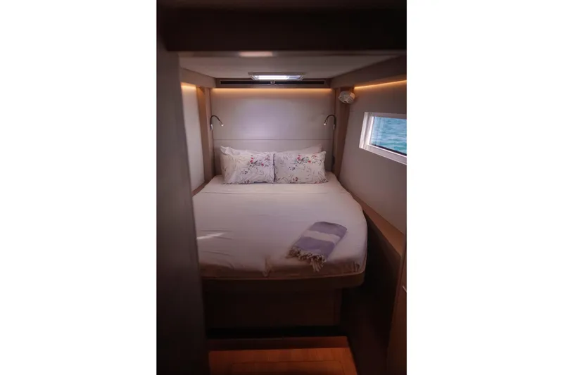 Slide: The Image of Luxurious cabin interior of 2024 Lagoon 51 yacht with cozy bed and window view. - 38