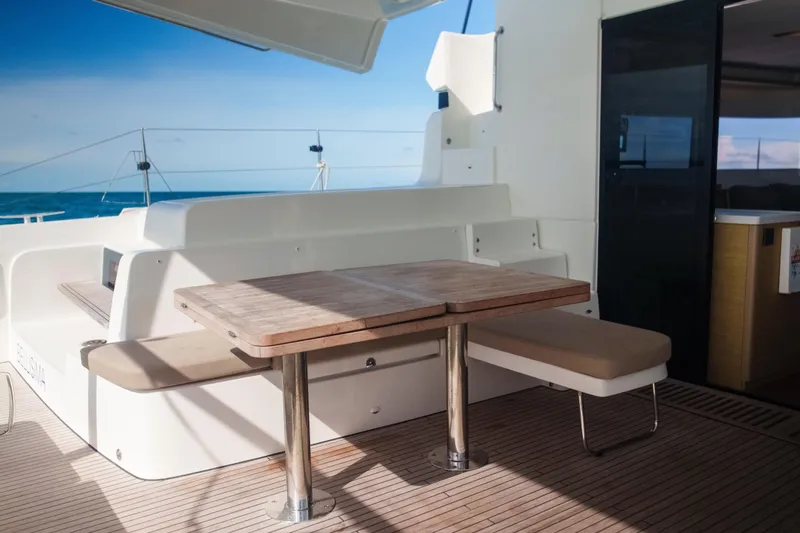 Slide: The Image of 2024 Lagoon 51 yacht deck with wooden table and ocean view. - 4