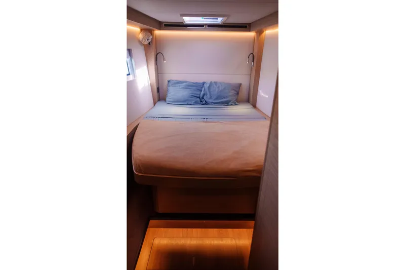 Slide: The Image of 2024 Lagoon 51 yacht cabin with cozy bed and ambient lighting. - 40