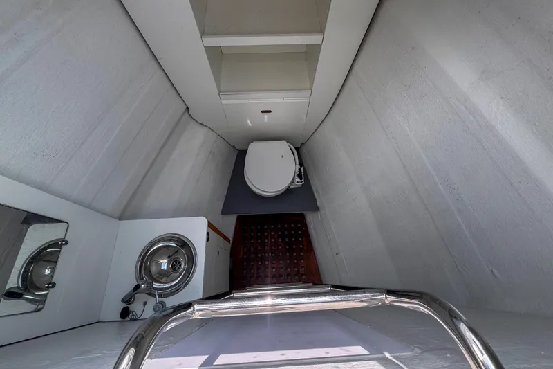 Slide: The Image of 2024 Lagoon 51 yacht bathroom with toilet, sink, and storage shelves. - 47