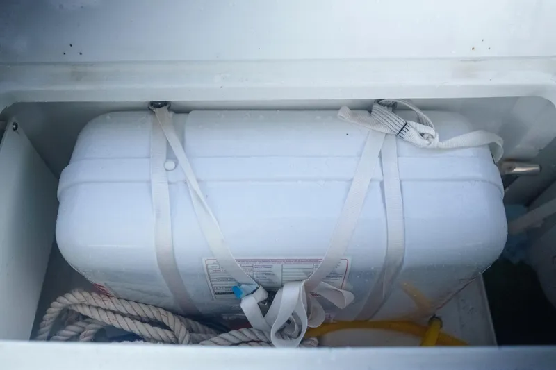 Slide: The Image of Storage compartment on 2024 Lagoon 51 yacht with secured white container and rope. - 54