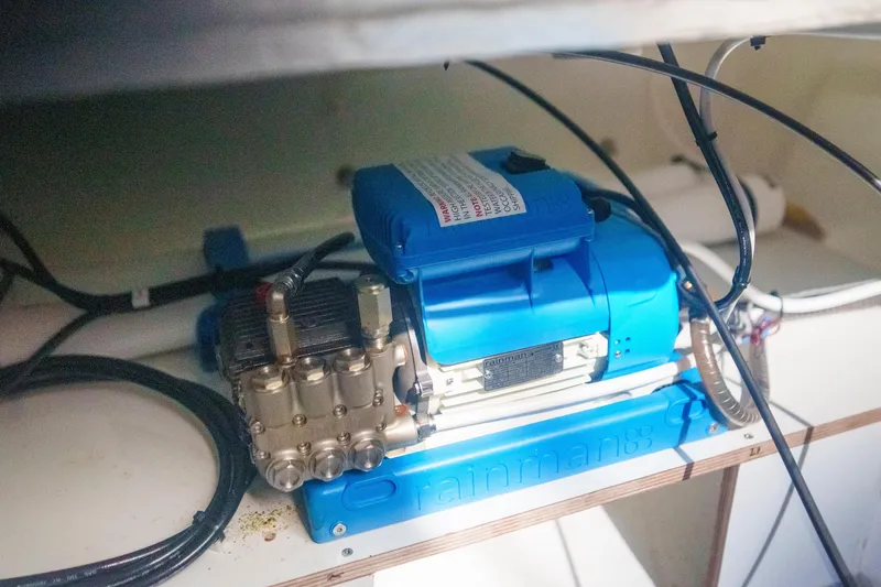 Slide: The Image of Engine compartment of 2024 Lagoon 51 yacht, featuring a blue Rainman watermaker. - 56