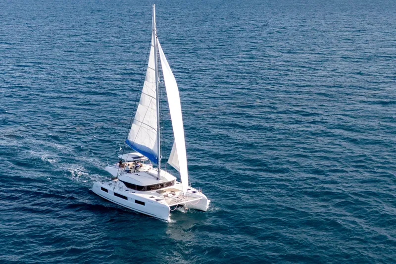 Slide: The Image of 2024 Lagoon 51 catamaran sailing on open sea, showcasing sleek design and spacious deck. - 59