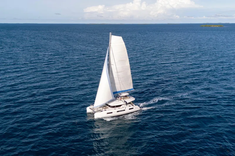 Slide: The Image of 2024 Lagoon 51 catamaran sailing on open ocean under clear skies. - 6