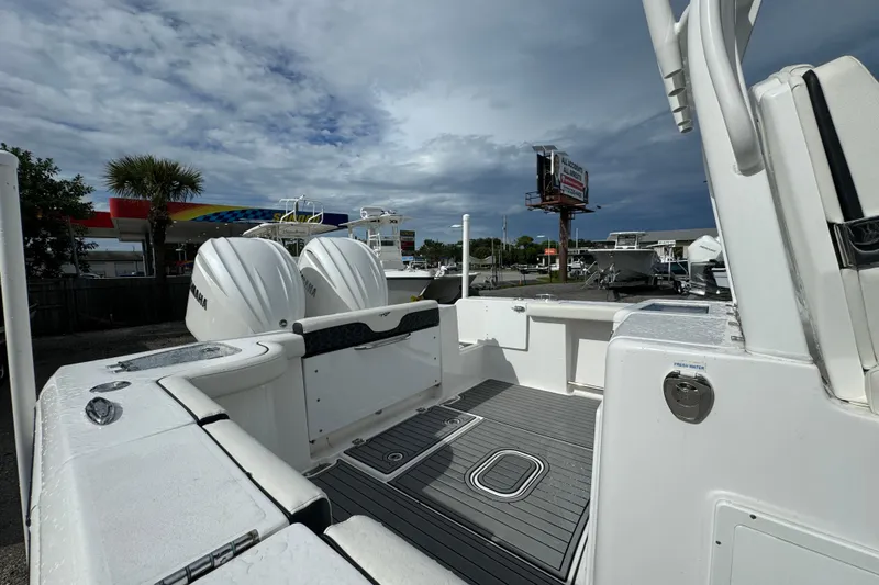 Slide: The Image of 2024 Tidewater 292 CC Adventure boat with dual Yamaha engines, docked under cloudy skies. - 12