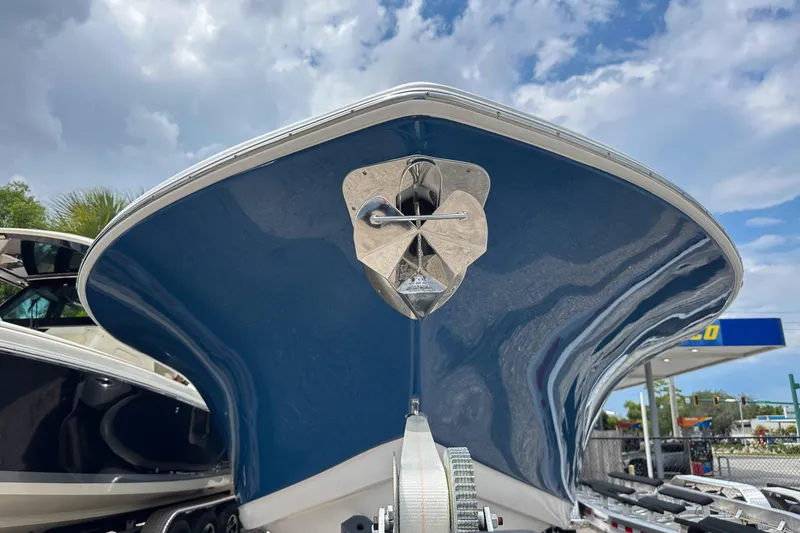 Slide: The Image of 2024 Tidewater 292 CC Adventure boat, blue hull, viewed from the front under a cloudy sky. - 5