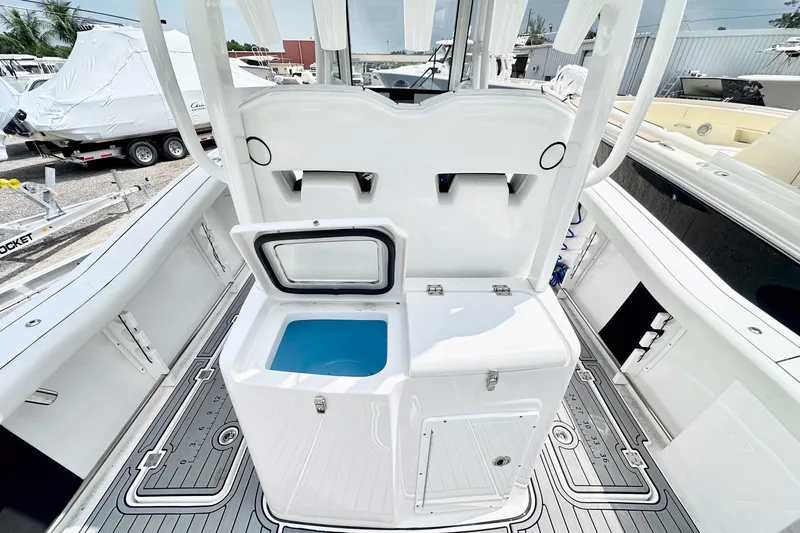 Slide: The Image of 2024 Tidewater 292 CC Adventure boat interior with open storage compartment and sleek design. - 9