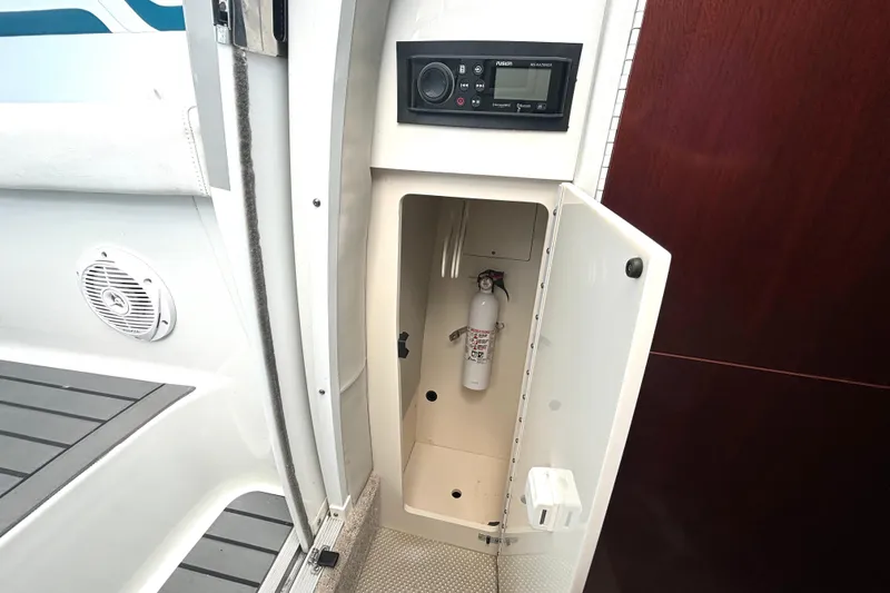 Slide: The Image of Open storage compartment on a 2006 Formula 400 Super Sport Crossover boat with fire extinguisher. - 53
