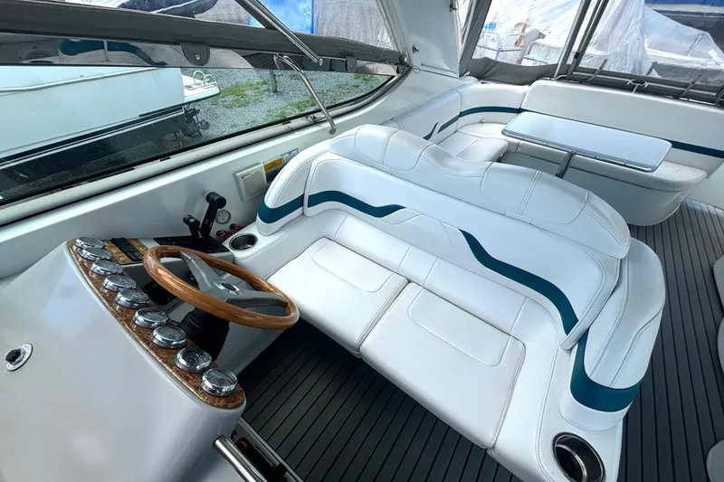 Slide: The Image of Interior of a 2006 Formula 400 Super Sport Crossover boat with white seating and wooden steering wheel. - 26