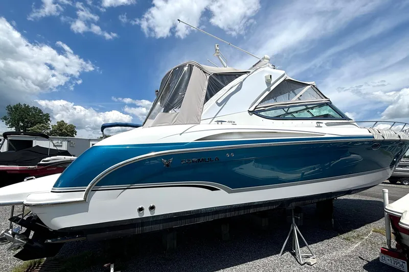 Slide: The Image of 2006 Formula 400 Super Sport Crossover boat displayed outdoors under a partly cloudy sky. - 5