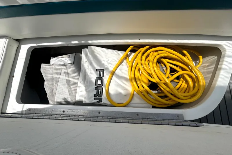 Slide: The Image of Storage compartment on a 2006 Formula 400 Super Sport Crossover with yellow cable and cover. - 54