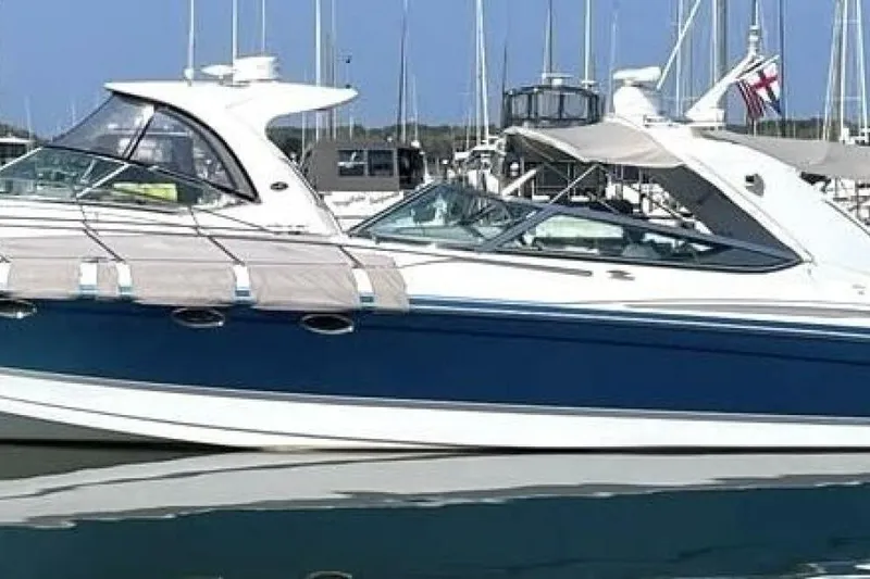 Slide: The Image of 2006 Formula 400 Super Sport Crossover boat docked in marina, blue and white design. - 60