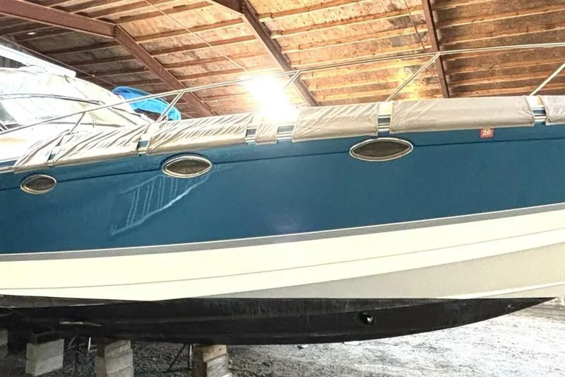 Slide: The Image of 2006 Formula 400 Super Sport Crossover boat in storage, blue hull, under wooden roof. - 5