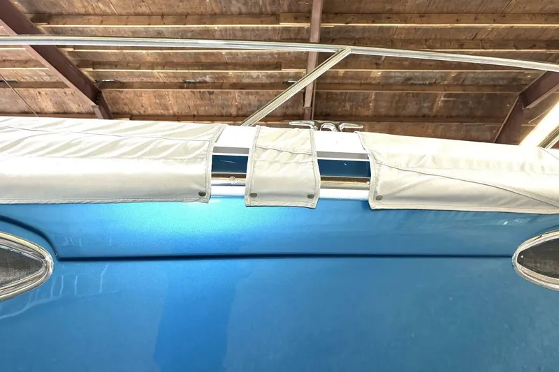 Slide: The Image of 2006 Formula 400 Super Sport Crossover boat under wooden roof, blue hull visible. - 61