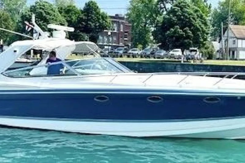 Slide: The Image of 2006 Formula 400 Super Sport Crossover boat on water, with trees and buildings in background. - 61