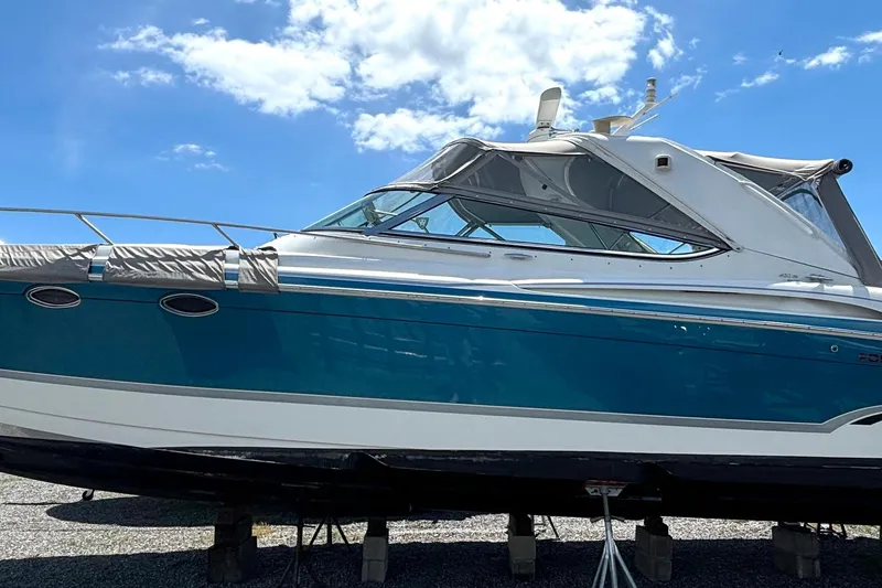 The Image of 2006 Formula 400 Super Sport Crossover boat on stands under a clear blue sky. - 1