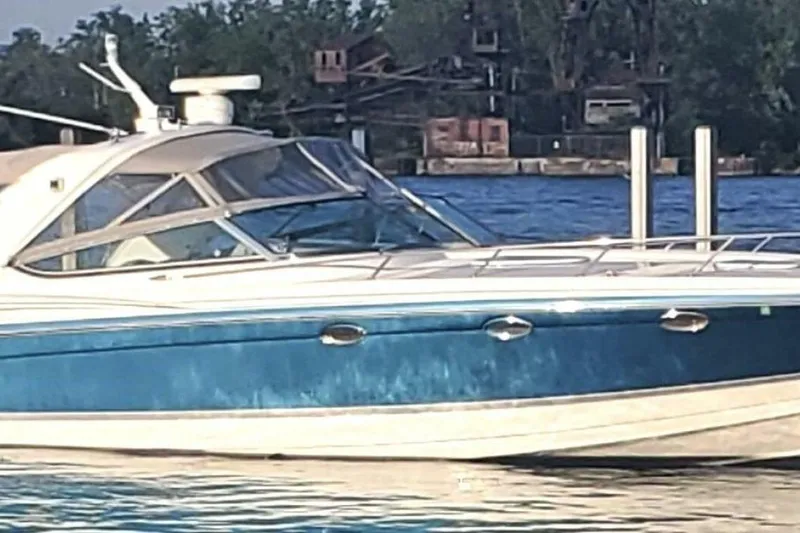 Slide: The Image of 2006 Formula 400 Super Sport Crossover boat on water, featuring sleek design and blue hull. - 59