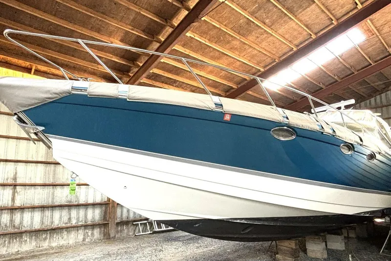 Slide: The Image of 2006 Formula 400 Super Sport Crossover boat stored indoors, blue hull, covered deck. - 9