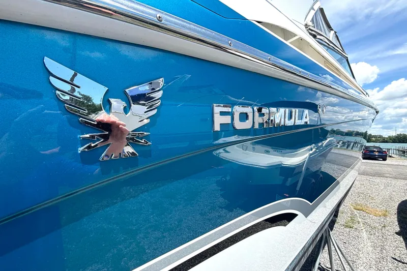 Slide: The Image of Blue 2006 Formula 400 Super Sport Crossover boat with chrome logo and sunny sky reflection. - 10